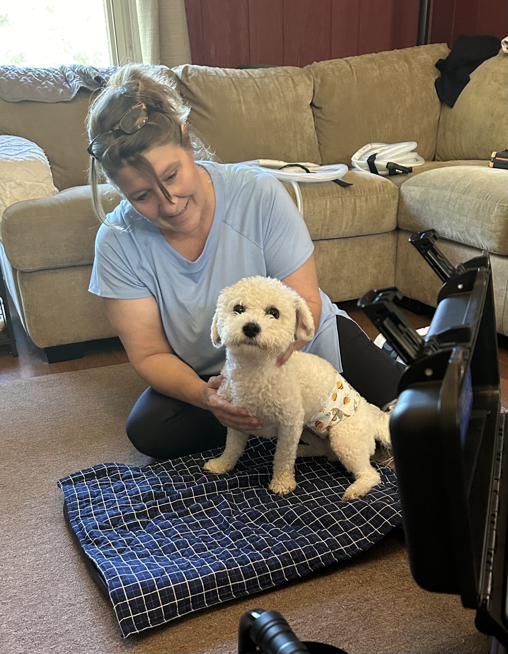 A woman is sitting on the floor with her dog